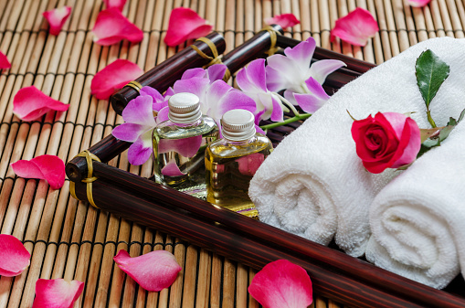 closeup of two essential oil, towel and flowers  