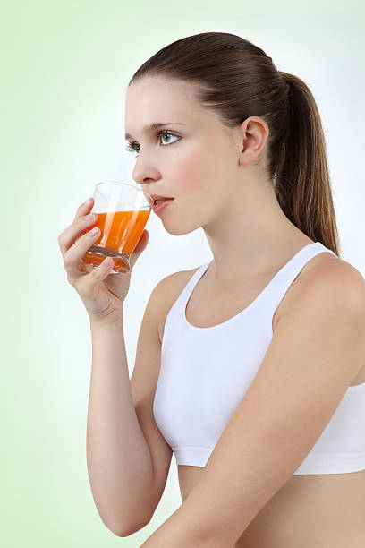 istock woman drinking orange juice vitamin 470199079