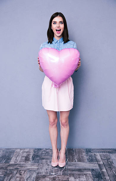 istock Surprised woman holding balloon 470199136