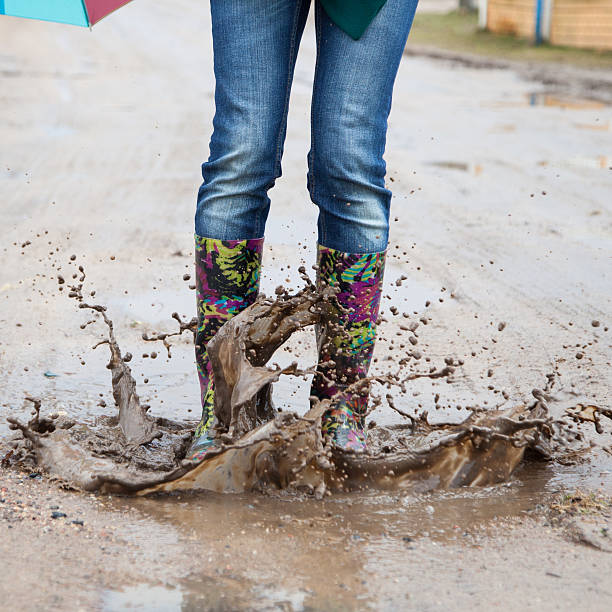 istock Woman in rain boots jumps 470204242