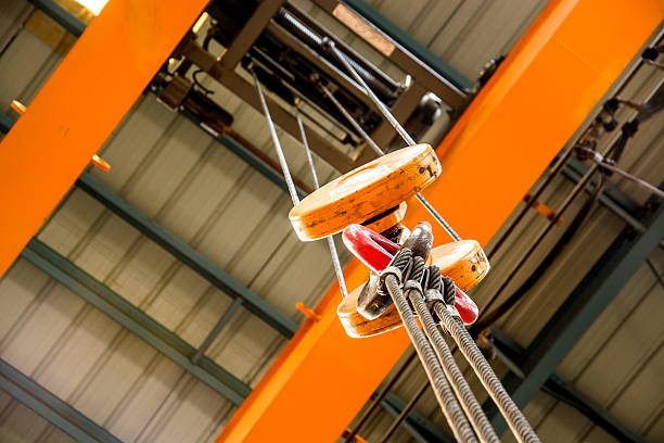 Close-up of an orange crane pulley over an orange ceiling stock photo