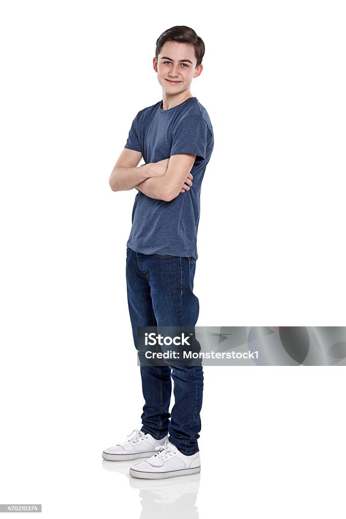 Smart young boy posing for camera Studio shot of smart young boy standing with his arms crossed on white background White Background Stock Photo