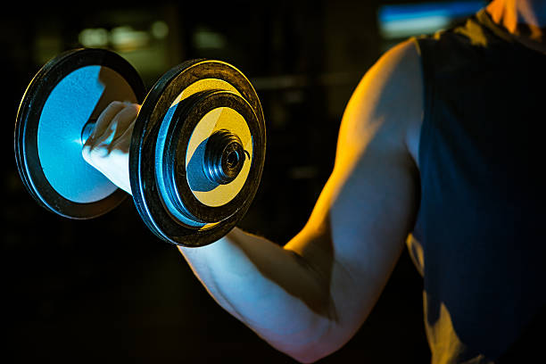 Man curling hand weights Muscled arm holding dumbbell weight. Bicep workout. Focus on dumbbell bicep curl stock pictures ripl fitness