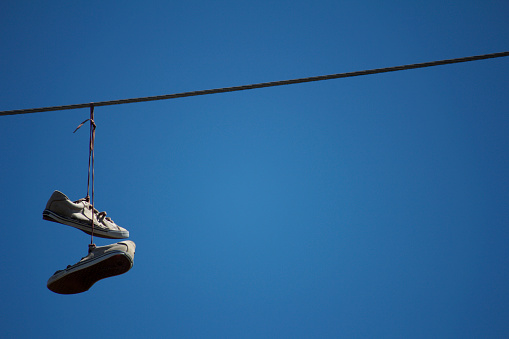 Shoes hanging from a telephone wire. 