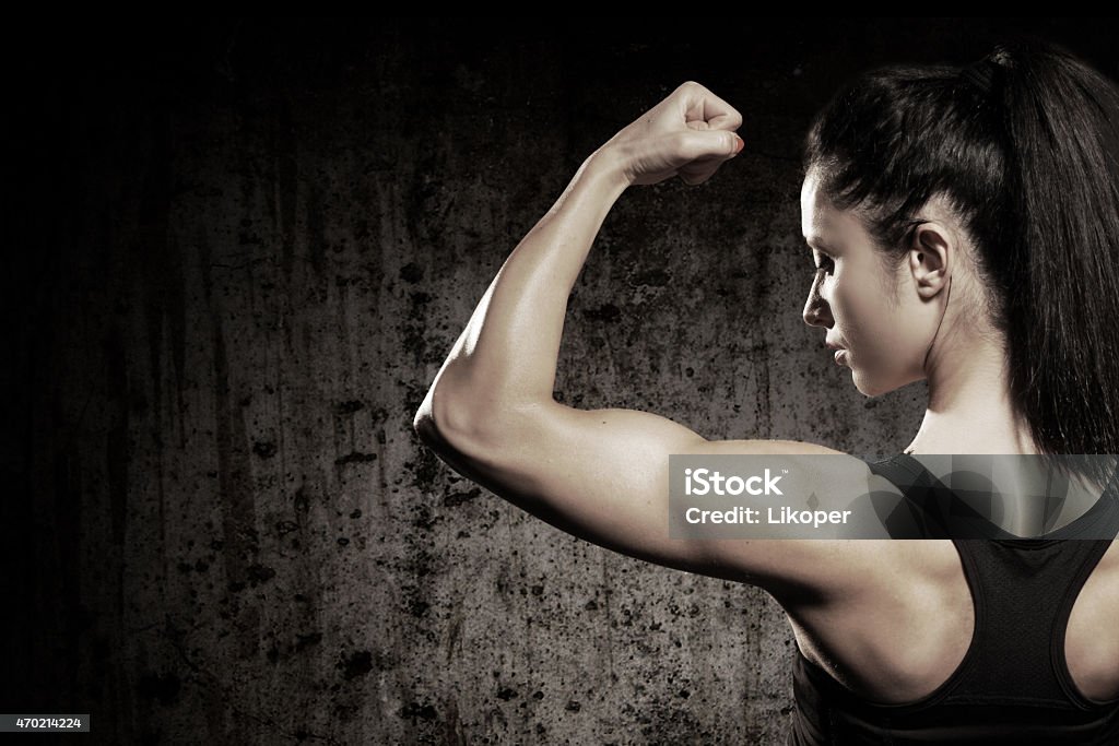 A strong woman flexing her muscles Muscular body with perfect abs Muscular Build Stock Photo