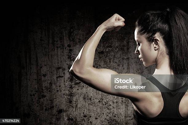 A Strong Woman Flexing Her Muscles Stock Photo - Download Image Now - Muscular Build, Mass - Unit of Measurement, Women