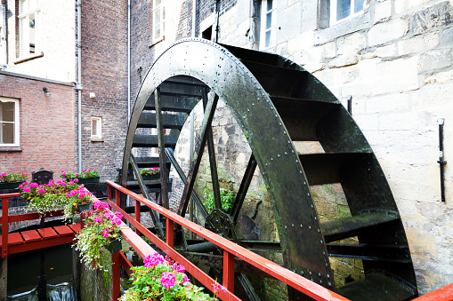 Maastricht, The Netherlands - September 18, 2014: Moving old water wheel of Bisschopsmolen in Maastricht. River Jeker is turning wheel slowly. Still used for grinding flour of baker. Landmark of town.