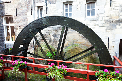 Maastricht, The Netherlands - September 18, 2014: Historical water wheel of Bisschopsmolen in Maastricht. River Jeker is turning wheel slowly. Still used for grinding flour of baker. Landmark of town.