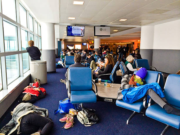 menschen schlafen auf dem boden am flughafen jfk, new york - delta air lines stock-fotos und bilder