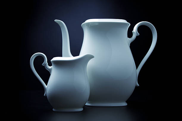 pair of teapots against black