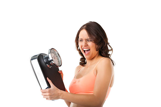giovane donna con scale di misurazione - emaciated weight scale dieting overweight foto e immagini stock
