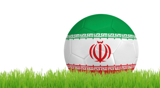 Soccer ball on green grass with colors of Iranian flag isolated on white background