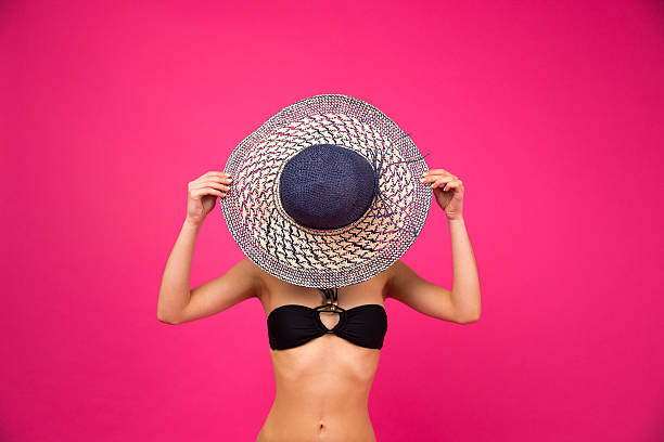 istock Woman in bikini covering her face with hat 470231160