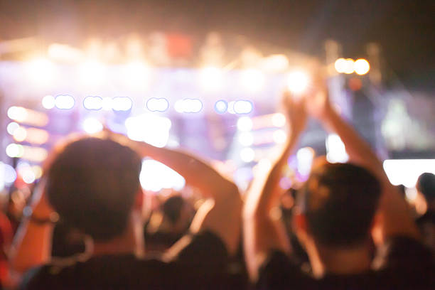 istock Blurred fans with arms raised at a concert 470233156