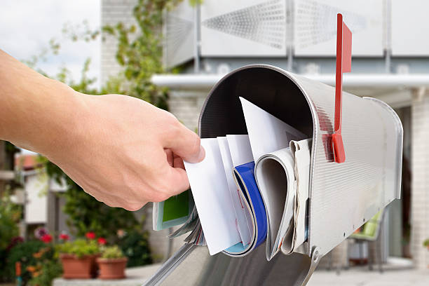 Man Taking Letter From Mailbox Close-up Of Man's Hand Taking Letter From Mailbox Outside House mailbox photos stock pictures, royalty-free photos & images