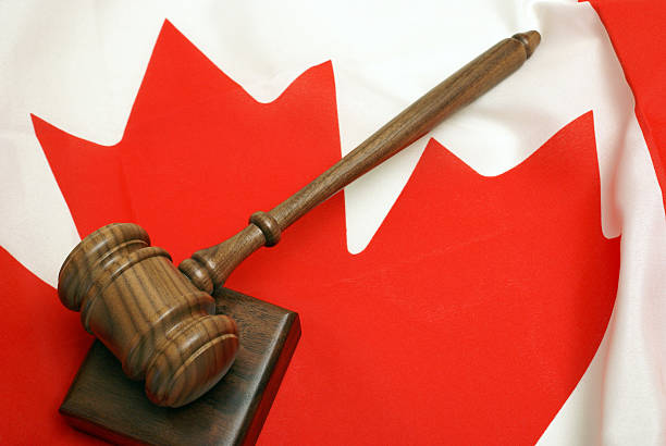 Wooden gavel resting on a block, atop a Canadian flag stock photo
