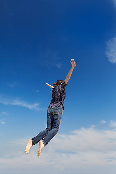 istock young woman jumping on the blue sky 470252640