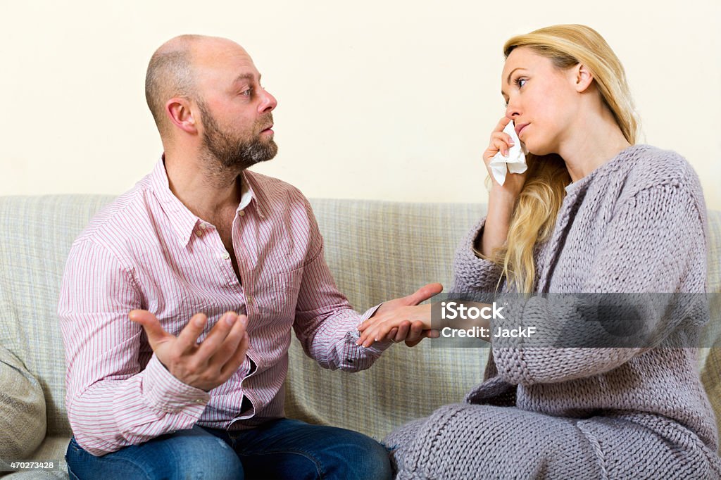 Man consoling woman Man asking for forgiveness from crying woman at home 2015 Stock Photo