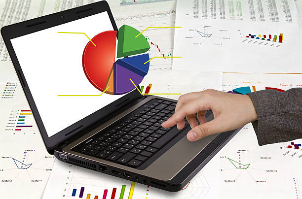 istock Female hands writing on laptop with financial Graphs 470277461