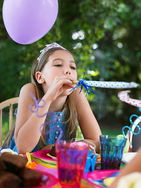 istock Girl Blowing Puffer At Birthday Party 470279135