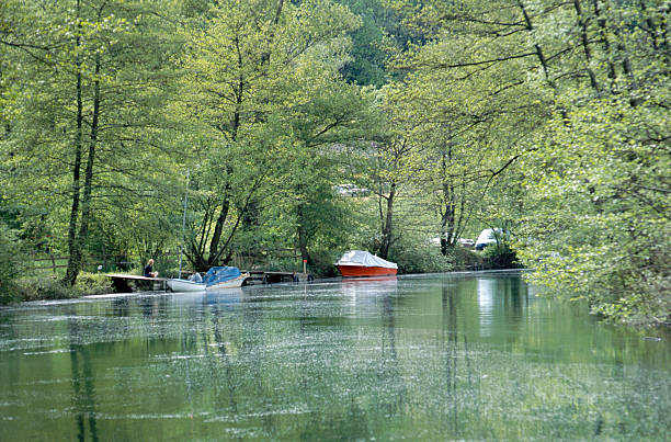 istock Green river and small motor boats 470279521