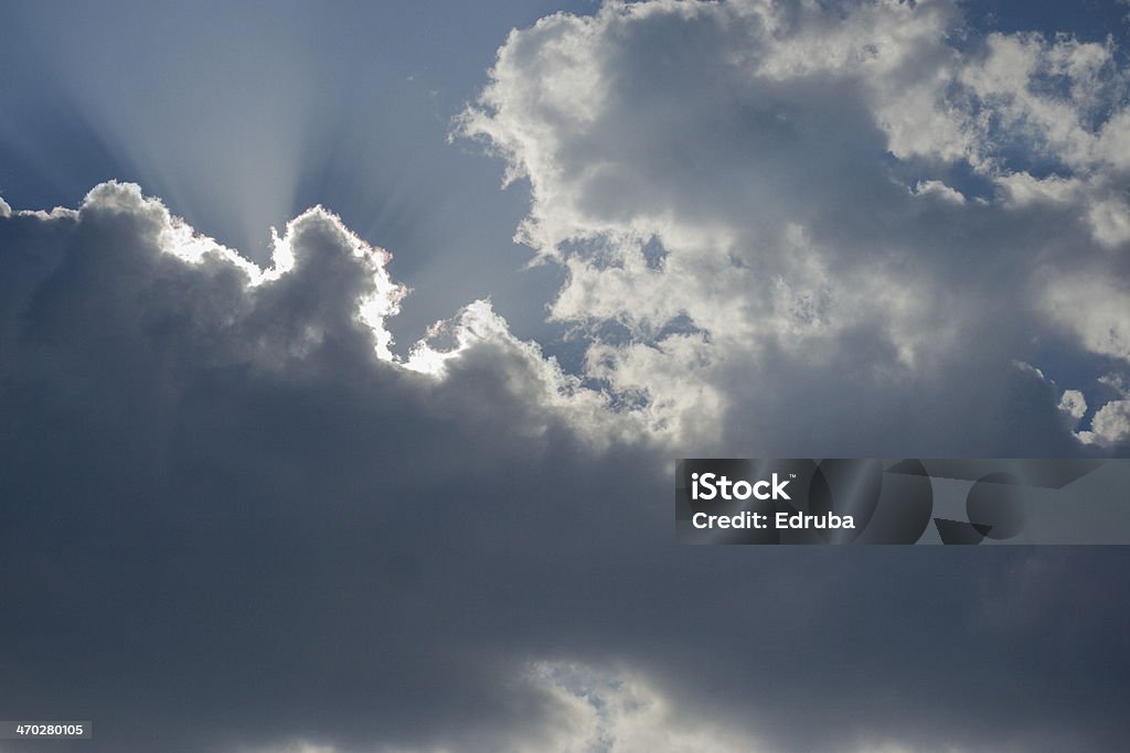 Sun Breaking Through Afternoon sun highlights high clouds. Blue Stock Photo