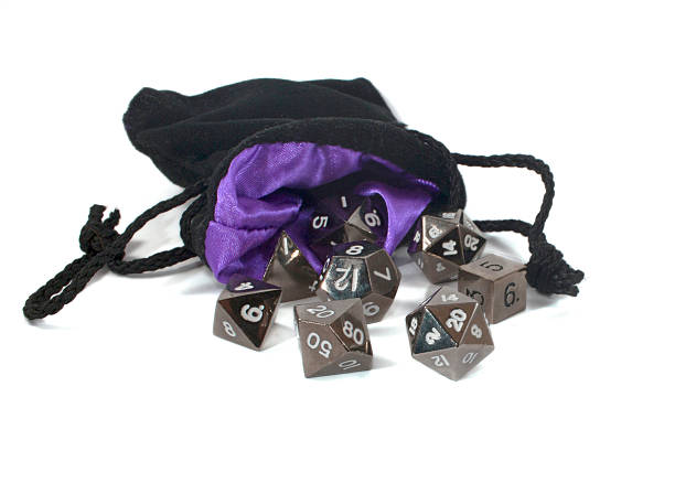 Polyhedral dice in a bag. Metal, polyhedral dice and a purple lined bag, isolated on a white background. developing 8 stock pictures, royalty-free photos & images
