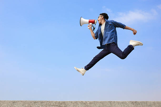 istock man jump and shout megaphone 470285348