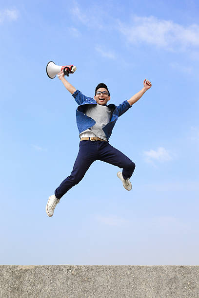 istock man jump and shout megaphone 470285536