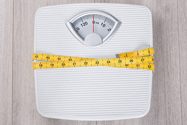 istock Weight Scale Wrapped In Measure Tape 470289516