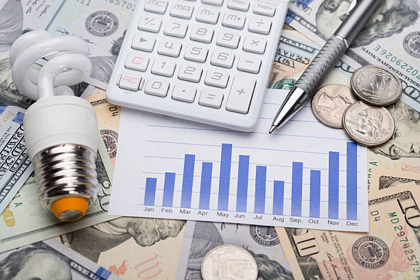 istock Bulb With Graph And Calculator On Dollar Bills 470293286