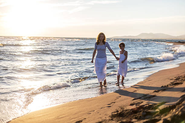 istock Family stroll along sandy beach 470301530