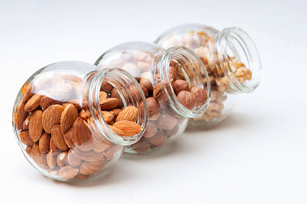istock Hazelnut , almond and walnut in glass jars. 470304776