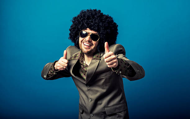 brutto e funky guy in abbigliamento degli anni settanta mostra thumbs up - kitsch men ugliness humor foto e immagini stock