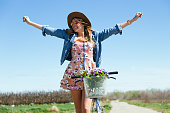 A beautiful young female riding a vintage bicycle in a field