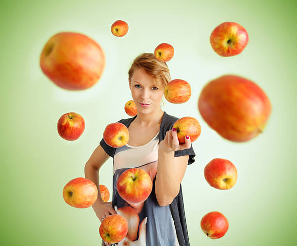 Nature Listens - Green Energy. Woman Listens To Music From Apple Fruit