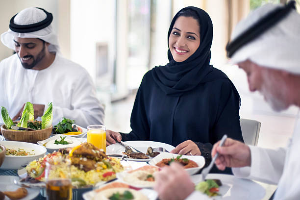 Middle Eastern woman eating with family