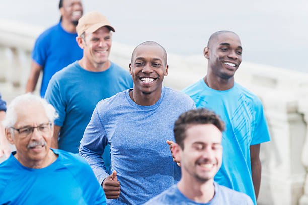istock Multiracial group of men in blue shirts running 470310504