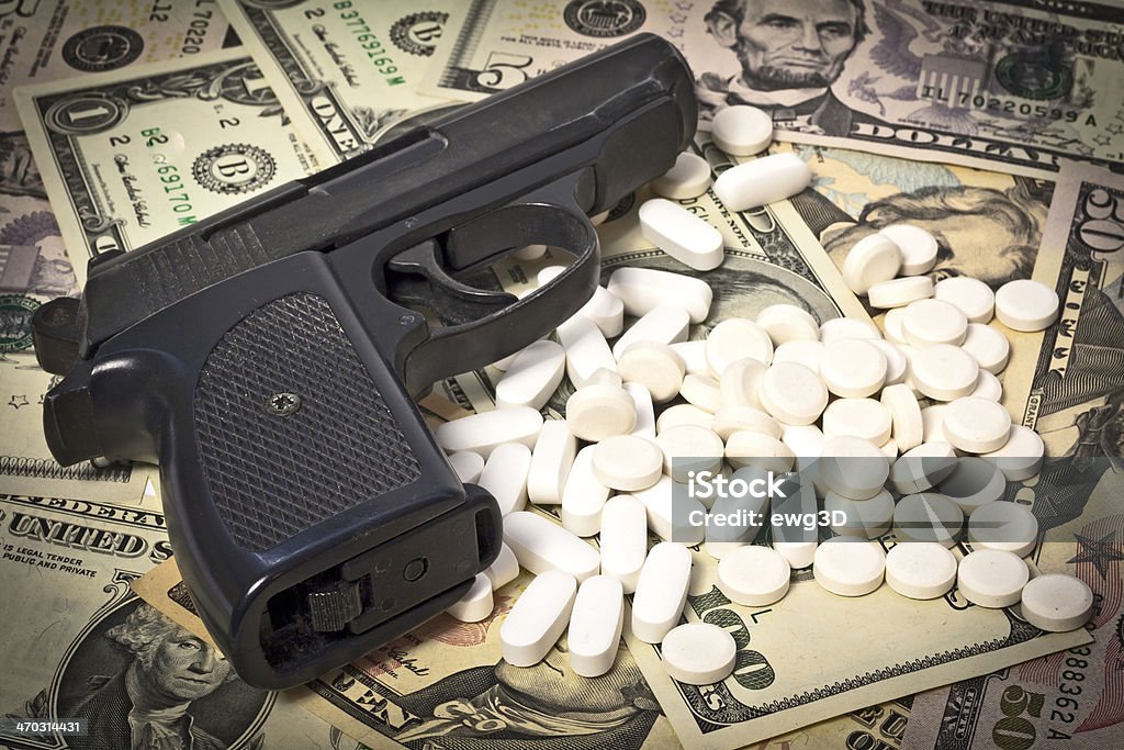 Immoral business Black handgun with pills and bills Narcotic Stock Photo