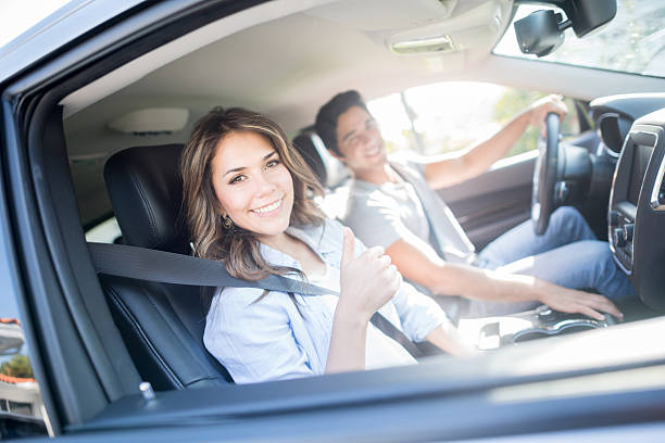 Happy couple going on a road trip Happy couple going on a road trip and showing thumbs up car insurance stock pictures, royalty-free photos & images