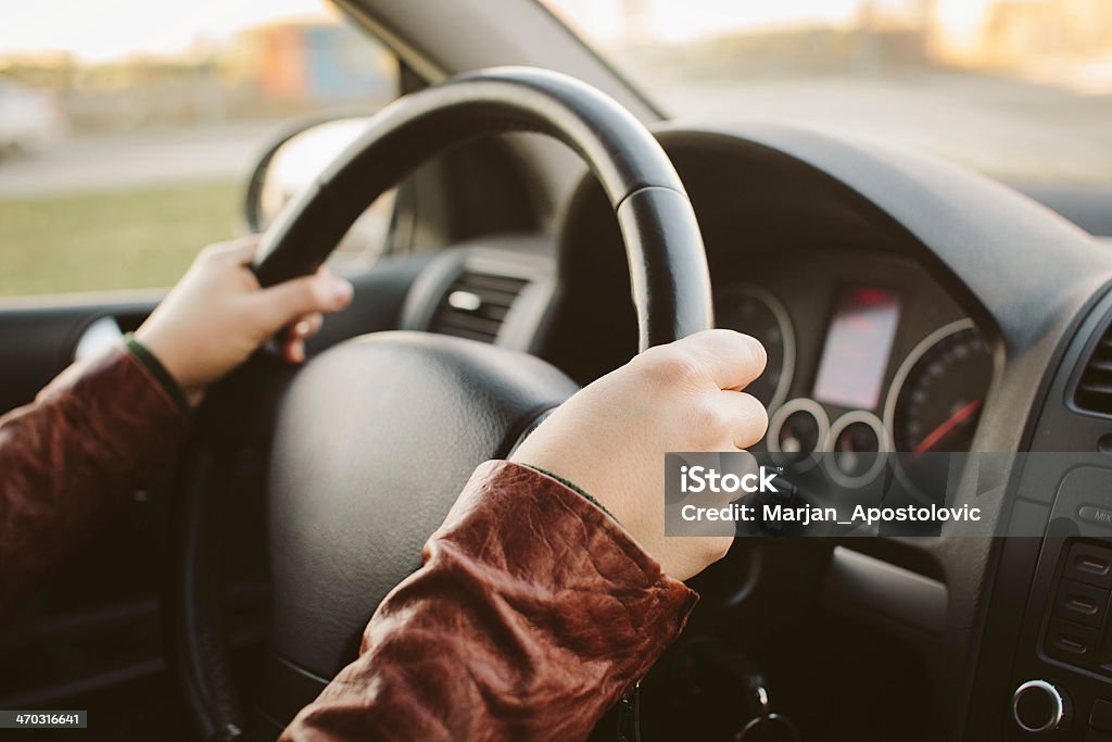 Close-up of hands on car steering wheel at 10 and 2 A woman driving a car Driving Test Stock Photo