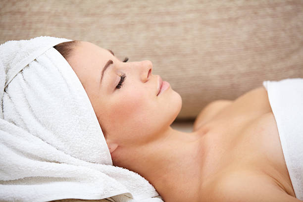 istock beautiful woman lying on a massage table with white towels 470316909