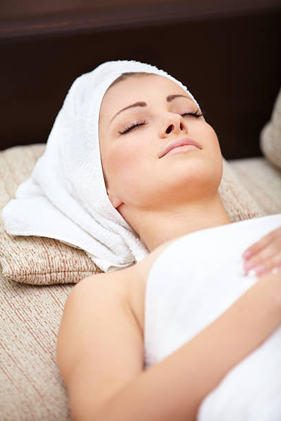 istock beautiful woman lying on a massage table with white towels 470316915