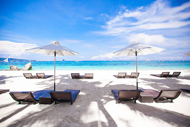 istock White umbrella and chairs at beach background the blue sea 470317035