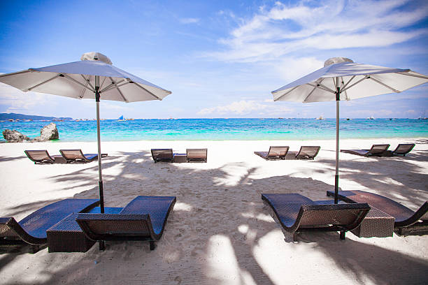 istock White umbrella and chairs at beach background the blue sea 470317091
