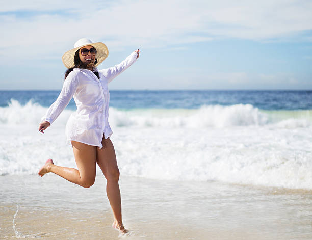 istock Playful woman having fun at the beach during summer day. 470318214
