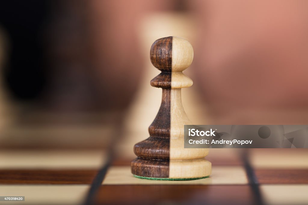 Merged Chess Pawns Closeup of merged chess pawns on chessboard Mergers and Acquisitions Stock Photo