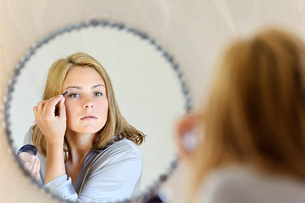 istock Beautiful young woman doing make-up 470321762