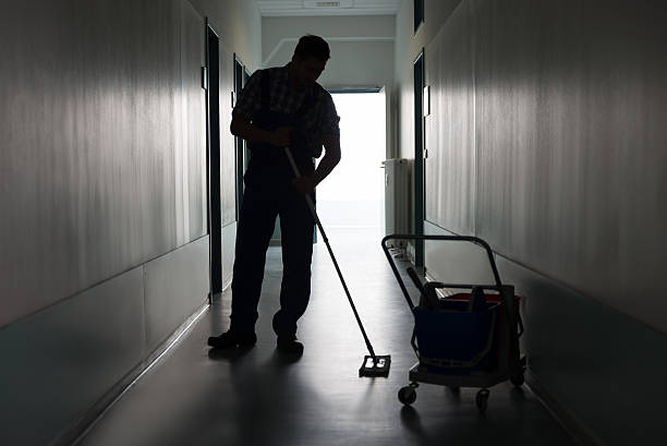 mann mit besen reinigung büro-korridor - hausmeister stock-fotos und bilder