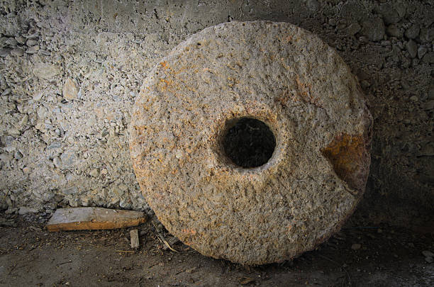 Photo of millstone leaning against wall stock photo